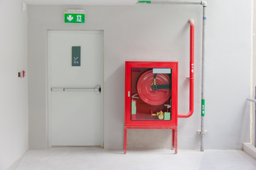 Fire rated door with fire hose beside it